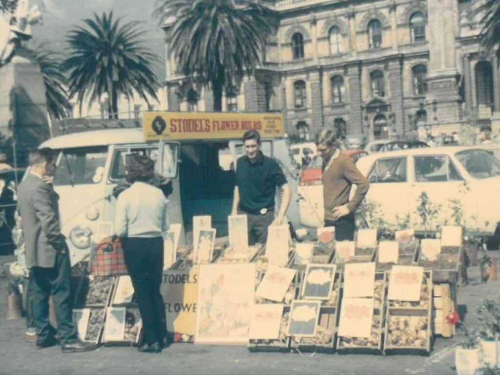 People browsing and buying artwork outside the Stodels Flower Bulbs minibus.